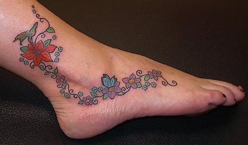 flower and butterfly tattoos on foot. foot tattoo photos submitted to RankMyTattoos.com �